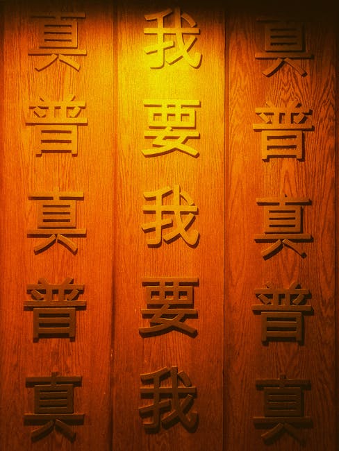 Intricate wooden calligraphy on a wall with warm ambient lighting.