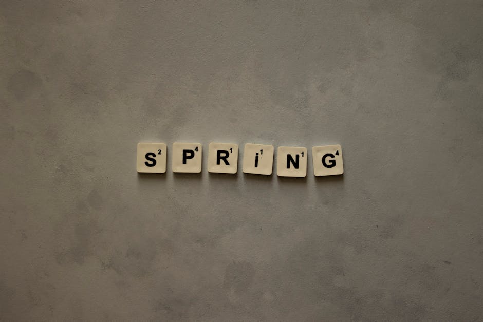 Scrabble tiles on textured surface spelling 'Spring', ideal for seasonal themes.