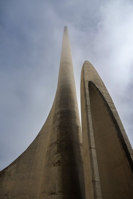 Looking up at the Afrikaanse Taalmonument in South Africa under a cloudy sky.