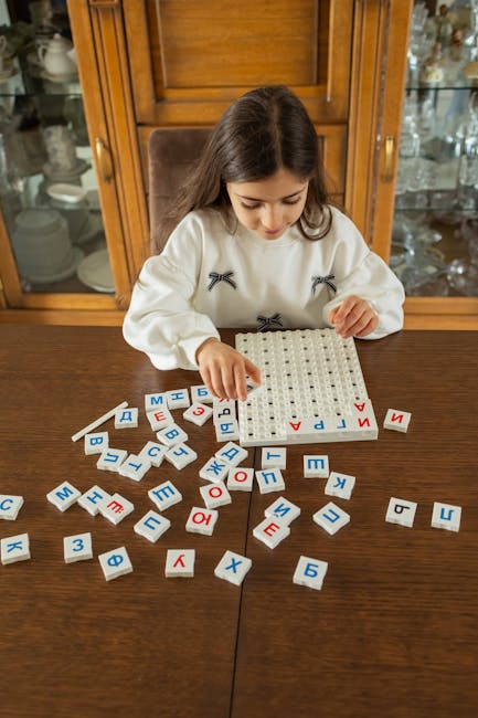 A young girl focuses attentively on completing an educational letter puzzle indoors.