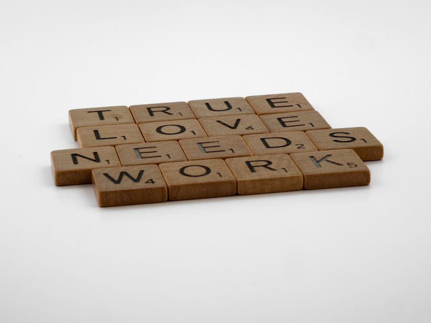 Wooden Scrabble tiles on white background spelling 'True Love Needs Work.'