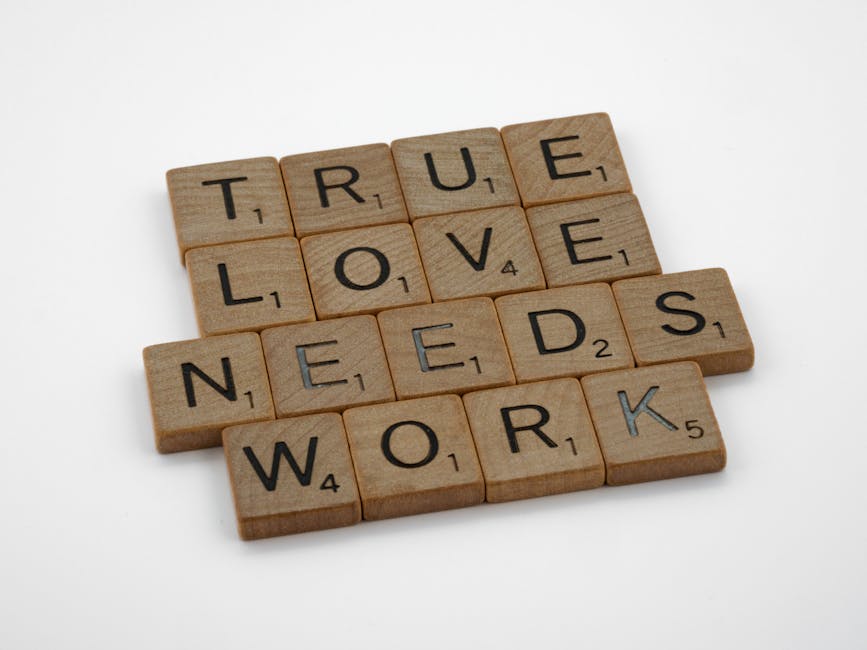 A close-up of wooden Scrabble tiles on a white surface spelling 'True Love Needs Work'.